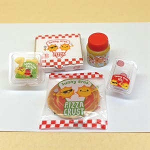 May include: A selection of miniature food items, including a pizza crust, pizza box, jar, and deli container. The items feature the "Sunny Bros." logo with smiling sun characters and the text "Pizza" and "Deli". The pizza crust is in a clear bag with a red and white checkered pattern.