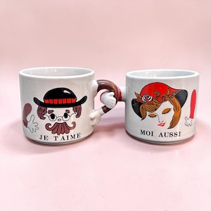 Op de afbeelding: Een set van drie keramische mokken met een gespikkelde, matte afwerking. De mokken zijn in de kleuren crème, lichtgrijs en donkergrijs. Elke mok heeft een eenvoudig, modern ontwerp en een afgeronde handgreep.