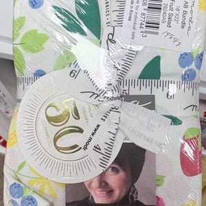 Può includere: Un pacchetto di tessuti Moda Fabrics AB Bundle Fruit Salad che misura 18 per 22 pollici, avvolto in plastica con un nastro a metro. Il tessuto presenta uno sfondo bianco con illustrazioni colorate di mirtilli, mele e foglie.