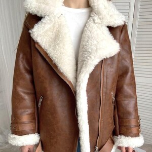 B3 bomber shearling jacket, women’s RAF aviator coat, vintage brown lambskin leather, distressed pilot bomber jacket, fur collar and cuffs coat, winter sheepskin outerwear women, handmade leather bomber coat, retro flight jacket for women, WWII pilot style shearling, warm winter aviator jacket, classic lambskin bomber, brown sheepskin winter coat, women’s distressed leather jacket, RAF bomber with fur trim, stylish flight bomber coat, real shearling pilot jacket, vintage warm leather coat