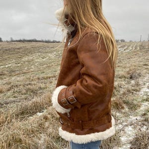 vintage sheepskin B3 jacket, RAF style pilot coat women, distressed lambskin shearling jacket, winter leather bomber with fur, brown aviator flight jacket, real shearling collar coat, WWII bomber style jacket, warm winter coat for her, leather pilot jacket women, handmade lambskin outerwear, vintage flight bomber women, brown fur-lined coat, soft leather winter jacket, stylish aviator bomber coat, women’s retro RAF jacket, B3 fur trim bomber coat, cozy winter lambskin shearling jacket