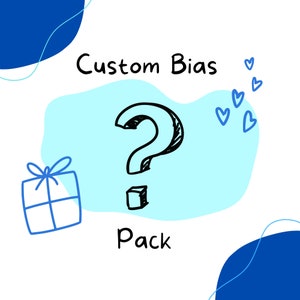 May include: A whimsical illustration featuring a large black question mark, a gift box, and blue hearts on a white background. The words "Custom Bias Pack" are written in black, suggesting a personalized or surprise product.