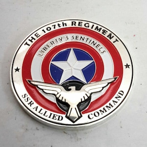 May include: A round silver pin with a red, white and blue American flag design. The pin features the text "THE 107th REGIMENT LIBERTY'S SENTINELS SSR ALLIED COMMAND" around the edge.