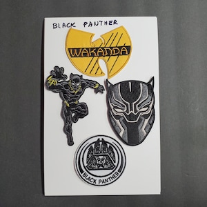 Pode incluir: Uma coleção de patches bordados com designs de Pantera Negra. Inclui um logotipo Wu-Tang Clan amarelo e preto com o texto "WAKANDA", uma máscara de Pantera Negra e uma figura de Pantera Negra.