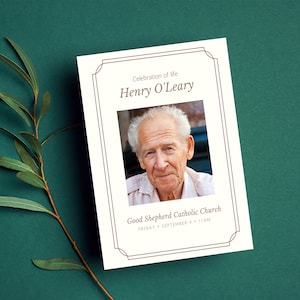 May include: A white funeral program with a brown border. The program includes a photo of a man, the text "Celebration of Life", the name "Henry O'Leary", and the information "Good Shepherd Catholic Church, Friday, September 9, 11AM".