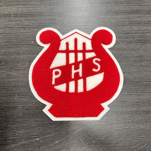 May include: A red and white felt patch in the shape of a lyre. The patch features the letters "P", "H", and "S" in white, with a white border. The patch is likely for a school or organization.