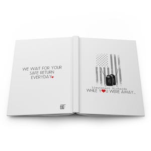 May include: An open book with a white background. The left page has the text "We wait for your safe return everyday." with a red heart. The right page has a gray and white American flag with two black dog tags hanging from it. The text "Lieutenant Richards while you were away..." is below the flag with a red heart.