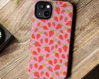 May include: A pink phone case with a pattern of red strawberries. The case has a camera lens cutout and a raised lip around the edges.