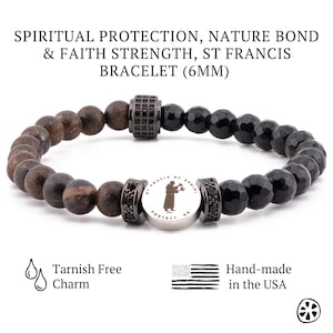Puede incluir: Pulsera de cuentas negras y marrones con un dije de plata que representa una silueta de San Francisco de Asís. El dije tiene las palabras "St. Francis of Assisi" y "Protect Us" grabadas. La pulsera tiene un diámetro de 6 mm y es resistente al deslustre.