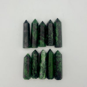 May include: A collection of ten green and black gemstone points, also known as zoisite, arranged in two rows. The points are polished and have a natural, irregular shape.
