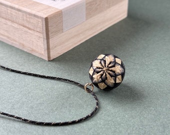 Japanese temari ball necklace "Kiku" with black and gold chrysanthemum flower. Traditional Japanese jewelry, silk embroidery, kumihimo cord.