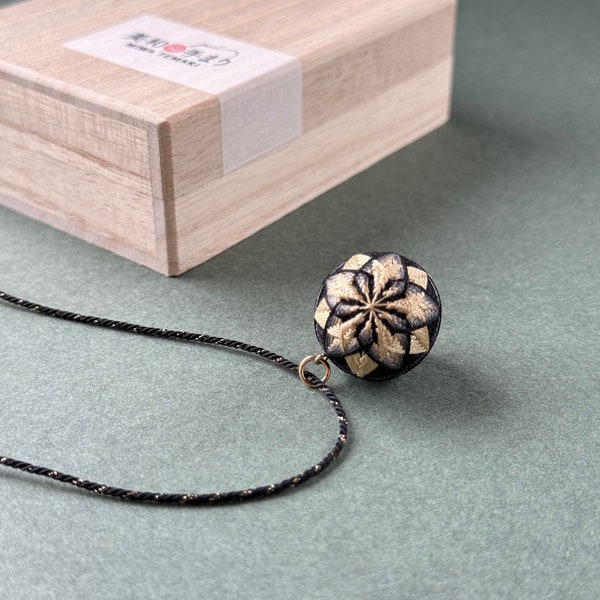 Japanese temari ball necklace "Kiku" with black and gold chrysanthemum flower. Traditional Japanese jewelry, silk embroidery, kumihimo cord.