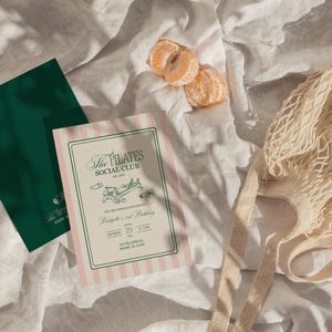 Puede incluir: Vista a&eacute;rea de una tarjeta verde y una invitaci&oacute;n a rayas rosas con el texto "The Pilates Social Club". Una bolsa de red y dos gajos de mandarina descansan sobre una superficie blanca texturizada.