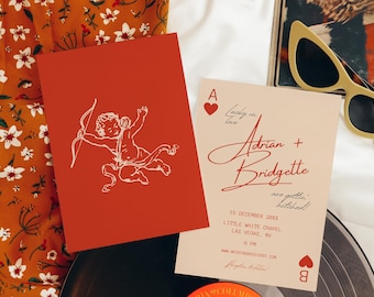 May include: A wedding invitation with a red heart and the text "Lucky in love Adrian + Bridgette are gettin' hitched!"  The invitation is on a cream background with a red border. The date, time, and location of the wedding are listed below the text. The invitation is surrounded by a floral pattern and a record player.