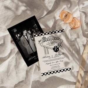 May include: Black and white wedding invitation with a checkered border. The invitation features a graphic of a Las Vegas sign that says "Just Married" and a dice. The text on the invitation reads "Adrian & Bridgette 12.15.20XX  Happily Ever After Party May 1st, 20XX at 6 PM 123 Lovers Lane Las Vegas, NV 12345 Please RSVP to Bridgette by March 1st, 20XX"
