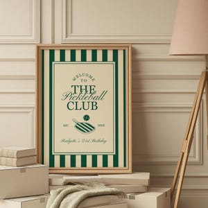 May include: A framed print with a green and cream color scheme. The print features the text "Welcome to The Pickleball Club" with a pickleball paddle illustration. The print is personalized with a name and birthday.