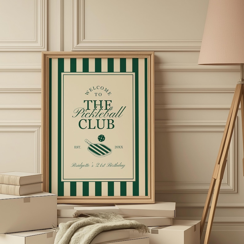 May include: A framed print with a green and cream color scheme. The print features the text "Welcome to The Pickleball Club" with a pickleball paddle illustration. The print is personalized with a name and birthday.