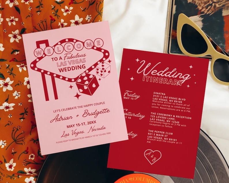 May include: A pink and red welcome card with a Las Vegas casino sign graphic. The card says "Welcome to a Fabulous Las Vegas Wedding" and includes the names Adrian and Bridgette. A red card with white text says "Wedding Itinerary" and lists the dates and times for the wedding events.