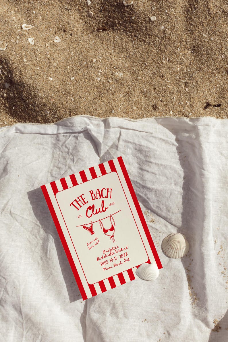 May include: A red and white striped invitation card for "The Bach Club" bachelorette weekend, with bikini illustrations, resting on a white cloth and sand. The card includes the text "Suns out, buns out!" and event details.