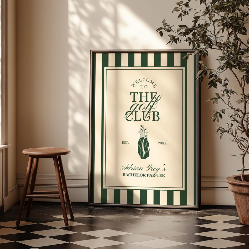 May include: A framed sign with a green and white striped border. The sign reads "Welcome to The Golf Club" with a golf bag graphic. Below the graphic, it says "Adrian Grey's Bachelor Par-Tee". A wooden stool and potted plant are in the foreground.