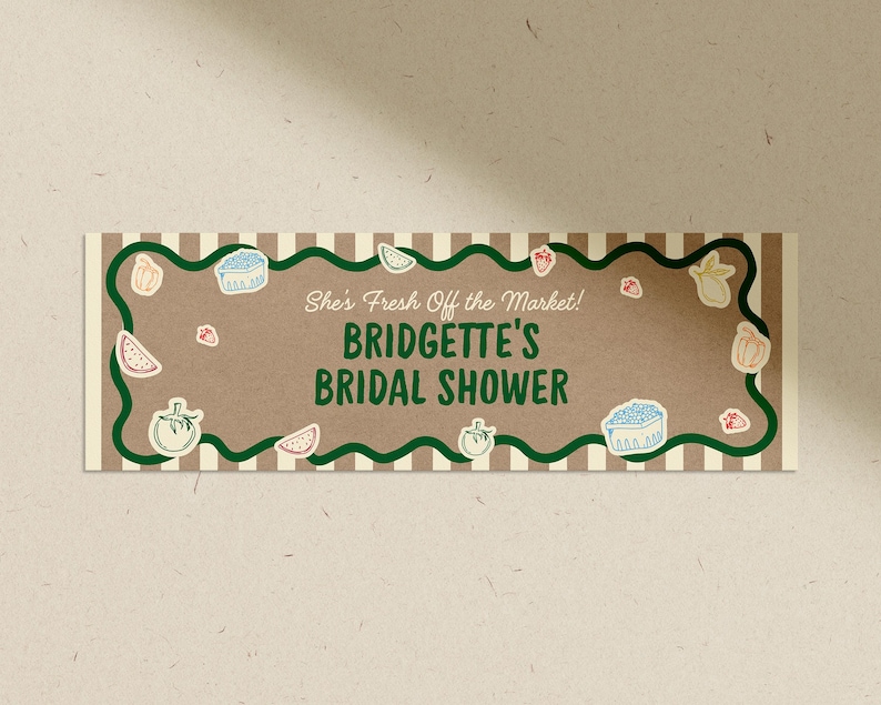 May include: A rectangular invitation with a brown background and the text "She's Fresh Off the Market! Bridgette's Bridal Shower." The invitation has a green wavy border and is decorated with illustrations of fruits and vegetables.