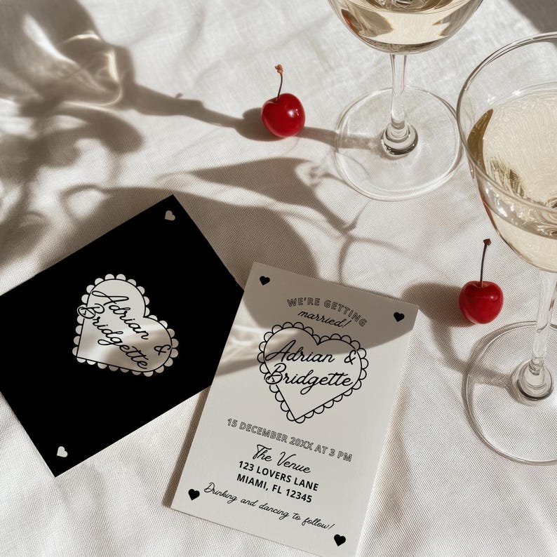 Op de afbeelding: Een witte huwelijksuitnodiging met zwarte tekst en een hartvormig ontwerp. De uitnodiging luidt "We're getting married! Adrian & Bridgette" en bevat de datum, tijd, locatie en het adres. De uitnodiging bevat ook de tekst "Drinking and dancing to follow!"