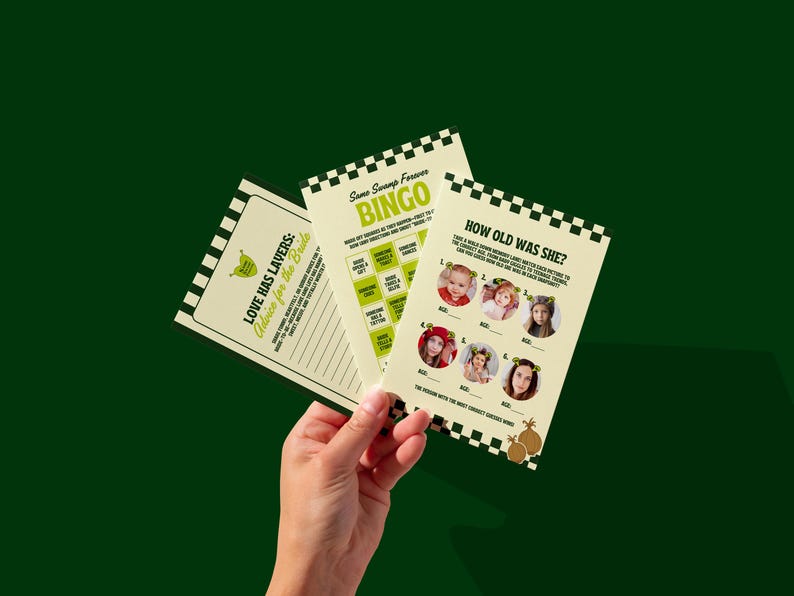 May include: Three printed cards with a green and white theme are held against a dark green background. The cards feature text and graphics, including the words "LOVE HAS LAVERS", "BINGO", and "HOW OLD WAS SHE?" The cards are designed for a bridal shower.