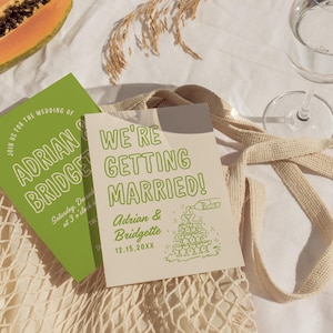 May include: A light brown card with green text announcing a wedding. The text reads "We're Getting Married!" with the couple's names, Adrian & Bridgette, and the date 12.15.20XX. A green illustration of a champagne tower is to the right of the text.