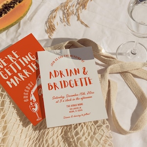 May include: Wedding invitation with the names Adrian & Bridgette in orange script. The invitation includes the date, time, and venue details. A second card reads "We're getting married! Cheers!" in white text on an orange background.