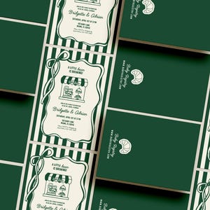 May include: An overhead shot of several dark green baby shower invitations and matching envelopes. The invitations feature a bakery illustration with the text "A little bean is brewing!" and the names Bridgette & Adrian.