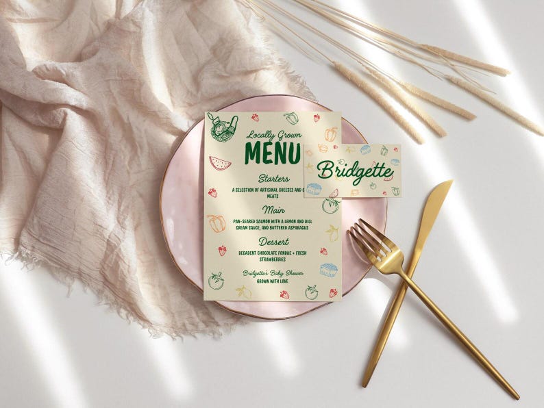 May include: A baby shower menu and place card with a pink plate, gold utensils, and decorative elements. The menu reads "Locally Grown Menu" with starter, main, and dessert options. The place card says "Bridgette".