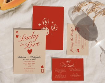 Könnte beinhalten: Eine Hochzeitseinladungssuite in einem roten und cremefarbenen Farbschema. Die Haupteinladung zeigt ein rotes Herz-Ass mit dem Text "Lucky in Love" und den Namen des Paares. Die RSVP-Karte hat eine rote Kirschgrafik und den Text "Joining the Party?" Die Detailkarte hat eine rote Kronengrafik und den Text "Details".