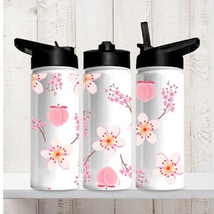 May include: Three white water bottles with black lids and straws. The bottles are decorated with pink peach and cherry blossom designs. The bottles are cylindrical and appear to be made of metal.