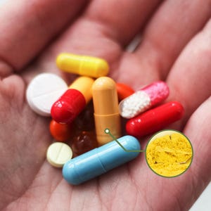 May include: A variety of colorful pills and capsules are held in a hand. The pills include red, yellow, blue, and white capsules and tablets. A close-up shows a yellow powder.