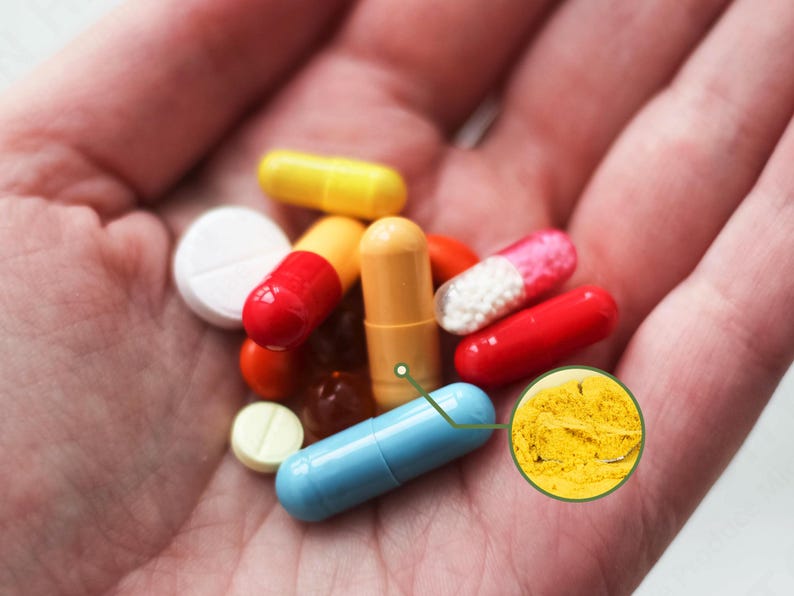 May include: A variety of colorful pills and capsules are held in a hand. The pills include red, yellow, blue, and white capsules and tablets. A close-up shows a yellow powder.