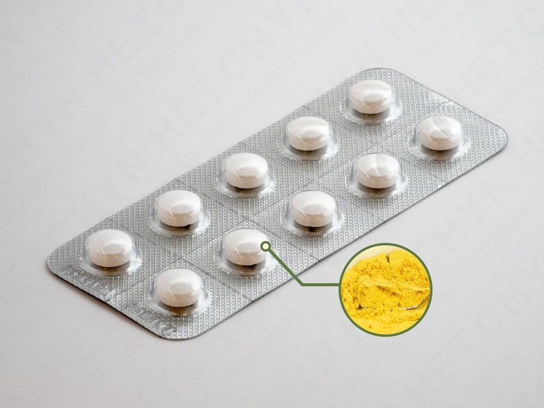 May include: A blister pack of white pills with a close-up of yellow powder. The pills are round and in a silver foil package. The yellow powder is in a circular inset.