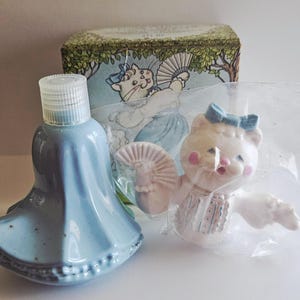 May include: A white ceramic mug with a black handle and the text "But First, Coffee" in a black, handwritten-style font. The mug is on a white surface.