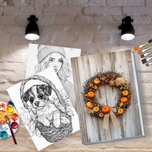 May include: Three black and white coloring pages featuring a woman with a beanie, a puppy in a basket, and a wreath with pumpkins. A paint palette with watercolor paints and paintbrushes are also included.