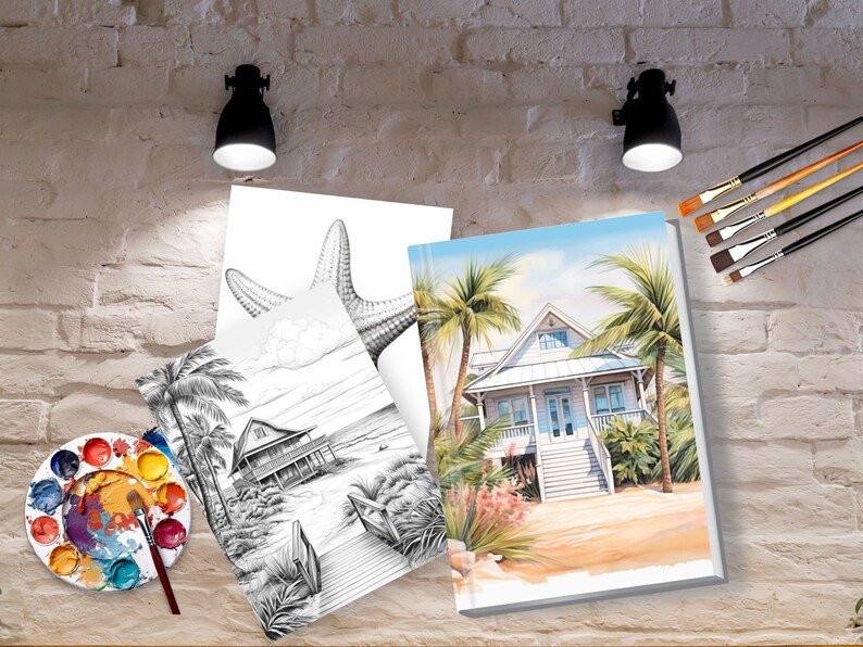 Op de afbeelding: Twee lege doeken met een strandhuis- en een zeesterontwerp. De doeken leunen tegen een bakstenen muur met kwasten en een palet in de voorgrond.