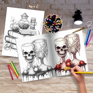 May include: A coloring book page featuring two skull-shaped goblets with dripping red liquid and red apples. The goblets are surrounded by vines and leaves. The page is open to reveal the coloring book's interior.
