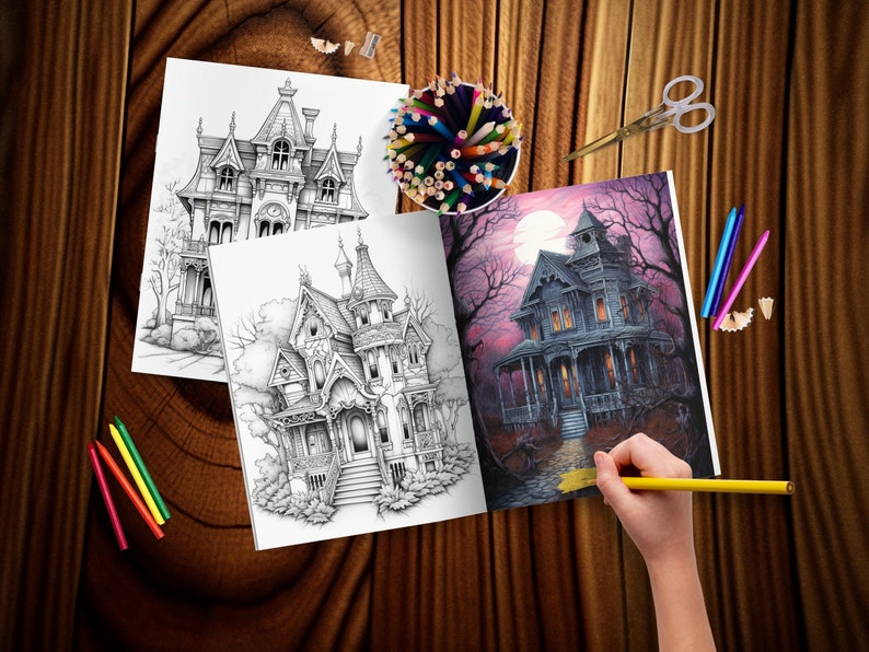 May include: An open coloring book with two black and white illustrations of a Victorian style house and a colored illustration of a spooky house with a full moon in the background. The book is on a wooden table with colored pencils and a pencil sharpener.