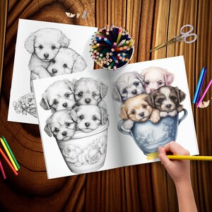 May include: A coloring book page with a black and white illustration of five puppies in a blue and white teacup. The puppies are all different breeds and have different expressions. The page is open to show the colored version of the illustration, which features a variety of colors, including brown, white, and black. The page is surrounded by colored pencils and a pencil sharpener.