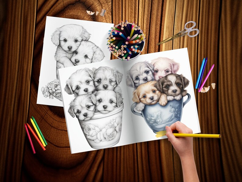 May include: A coloring book page with a black and white illustration of five puppies in a blue and white teacup. The puppies are all different breeds and have different expressions. The page is open to show the colored version of the illustration, which features a variety of colors, including brown, white, and black. The page is surrounded by colored pencils and a pencil sharpener.