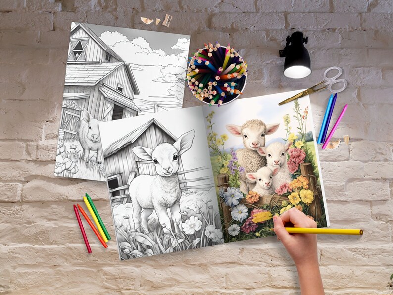 May include: An open coloring book with a black and white illustration of three lambs in a field of flowers. The book is open to a page with a black and white illustration of a lamb standing in a field. A person is coloring the lambs with a yellow colored pencil.