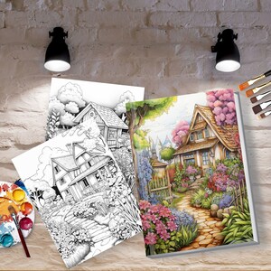 May include: Two coloring book pages featuring detailed illustrations of houses with gardens. The pages are open on a table with a paint palette and brushes.