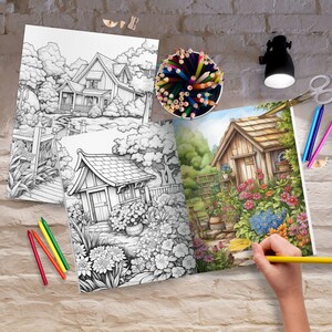 May include: An open coloring book with two pages showing black and white illustrations of houses and gardens. The left page is a finished illustration of a house and garden with colorful flowers and a blue sky. A person is coloring the right page with a yellow pencil.
