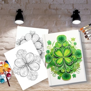 May include: A white book with a detailed green shamrock design, along with two black and white shamrock coloring pages. A watercolor palette and paintbrushes are also visible, suggesting an art or craft theme.