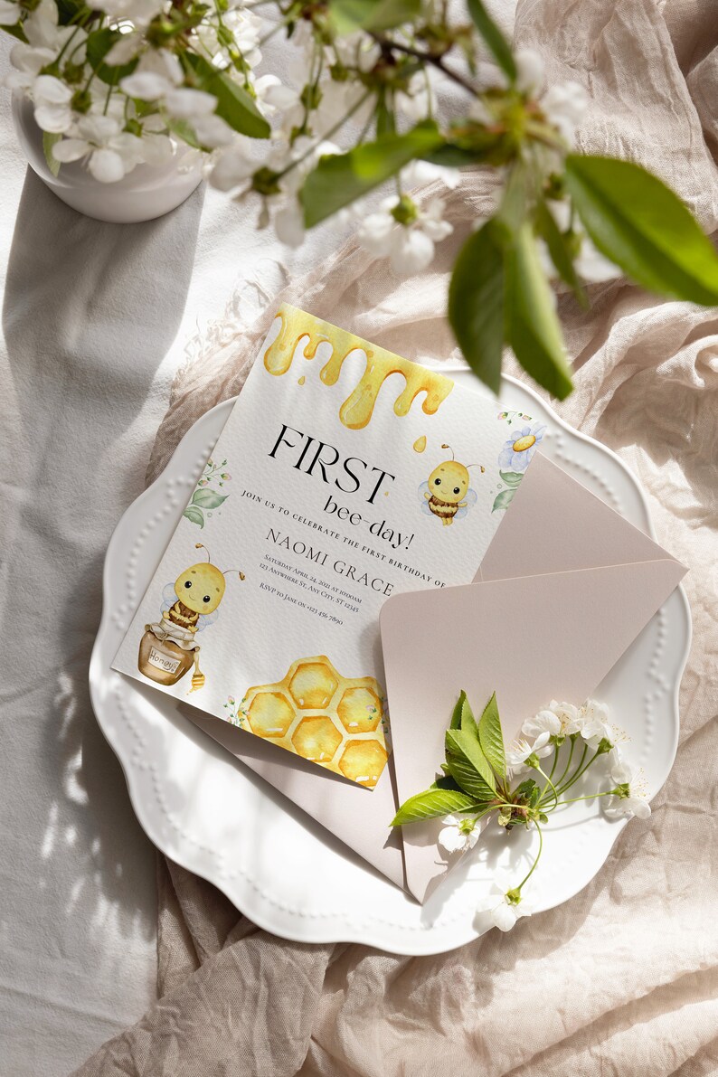May include: A yellow and white invitation card with a bee illustration and the text "FIRST bee-day!"  Join us to celebrate the first birthday of Naomi Grace. Saturday, April 22 at 2:00 PM. 341 Anywhere St. Any City, ST 12345. RSVP by Jan 12 at 621.555.2990.