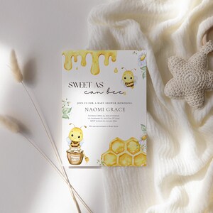 May include: A baby shower invitation with a watercolor illustration of a bee and honeycomb. The invitation reads "Sweet as can bee" and includes the name "Naomi Grace".