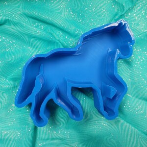 May include: A blue plastic horse-shaped mold for making crafts or baking.